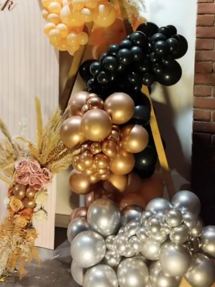 A close-up of the balloon details from Mehak's 25th birthday, showing the mix of black, silver, gold, and peach balloons with dried floral elements.