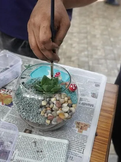 A close-up of a student creating a small terrarium during our workshop at the university. Even with simple materials, you can create something beautiful.