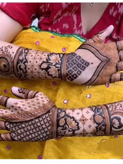 This is a back-hand bridal design, which is just as important as the front. It features large, bold motifs like the evil eye design and lotus flowers, ensuring your hands look beautiful from every angle.