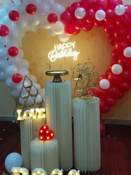 A beautiful close-up of a romantic birthday setup, featuring a heart-shaped balloon arch in red and white, perfect for expressing your love.