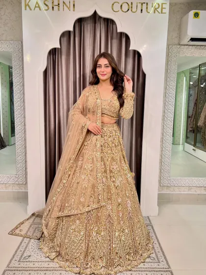 A full-length shot of a model in a glittery golden lehenga. This is the ultimate glam outfit for a sangeet or reception.