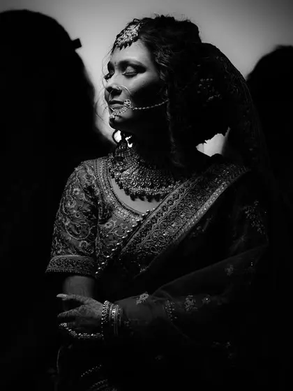 A black and white artistic portrait that plays with silhouettes and shadows. This image creates a sense of mystery and elegance, focusing on the bride's profile and the timeless beauty of her form.