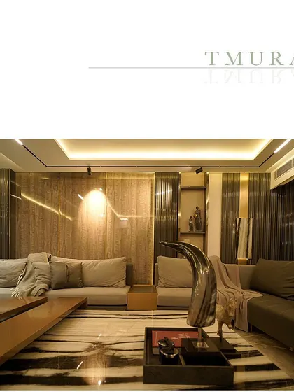 A wide shot of a lounge area, showing the dramatic contrast of the Panda White marble coffee table against the warm, wood-paneled walls. This demonstrates our principle of balancing bold patterns with subtle textures.