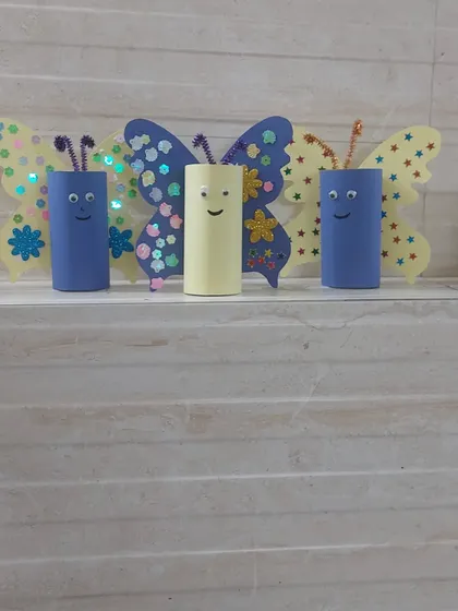 A family of butterfly crafts made from toilet paper rolls and decorated with colorful paper and sequins. This is a great example of our sustainable and imaginative DIY projects.