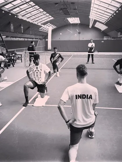 Leading a group warm-up session on an indoor court. Synchronized movements like these lunges help build team cohesion while properly preparing the athletes' muscles for the intense session ahead.