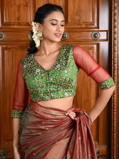 A beautiful green blouse with sheer red sleeves, both featuring delicate floral embroidery.
