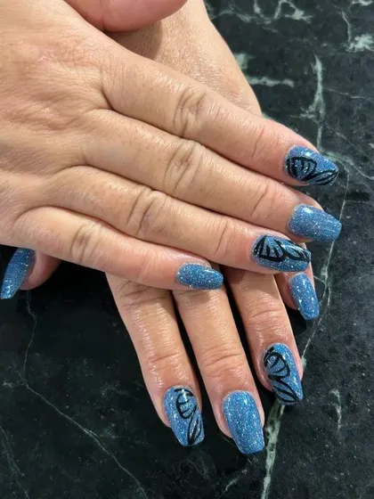 A magical look featuring a sparkling blue glitter base with hand-painted black butterfly wings.