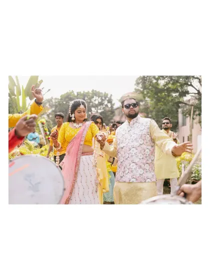 The grand entrance to the Haldi ceremony, with the couple led by dhol players. The energy is palpable as they dance their way into the celebration, surrounded by friends and family.