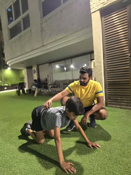 Proper form is everything. Here, our coach guides a young athlete through a bear crawl, an excellent functional exercise for building core strength and shoulder stability, crucial for any cricketer.