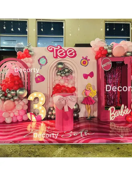 The full Barbie stage setup, including a doll box photo booth and vibrant pink flooring.
