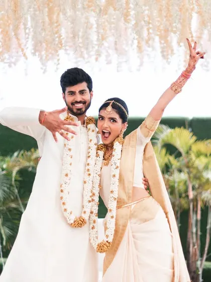 A fun, high-energy pose from a South Indian wedding. This shows the couple's playful side and their excitement on the big day.