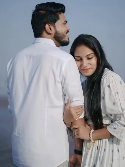 A sweet and simple pose, with her resting her head on his shoulder as they look out at the sea. It’s a moment of quiet companionship.