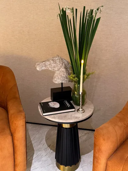 Even small side tables get our full attention. A minimalist floral arrangement paired with a candle and curated decor objects creates a stylish vignette.