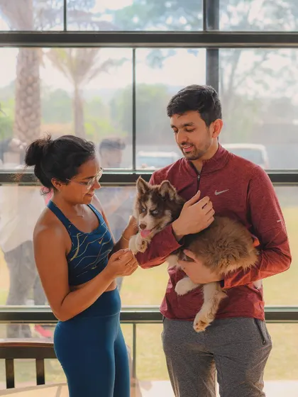 A couple enjoying a moment with a fluffy husky puppy during our Pawga event.