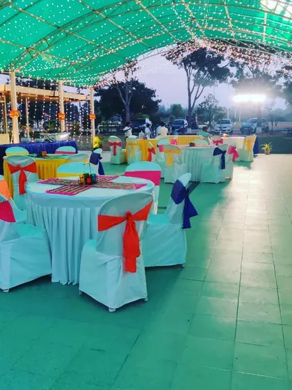 The dining area at an evening Mehandi function, with colorful chair ties and table runners. We help create a festive atmosphere for your celebrations.