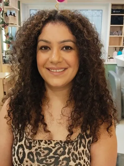 A stunning transformation for curly hair. The new colour enhances her natural curls, giving them definition and a healthy shine after an Olaplex treatment.