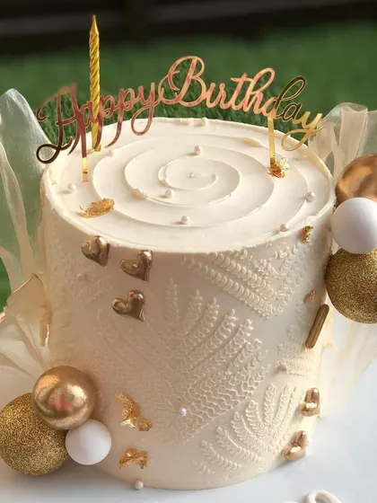 A close-up of the textured anniversary cake, showing the gold and white details.