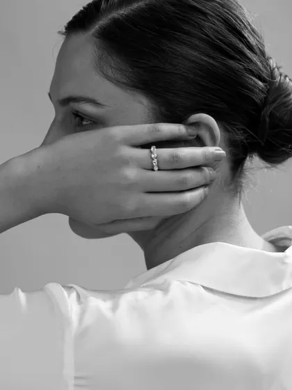 A unique angle that showcases a beautiful three-stone ring. By framing the shot from behind, the focus is entirely on the hand and the jewellery, creating a sense of mystery and elegance.