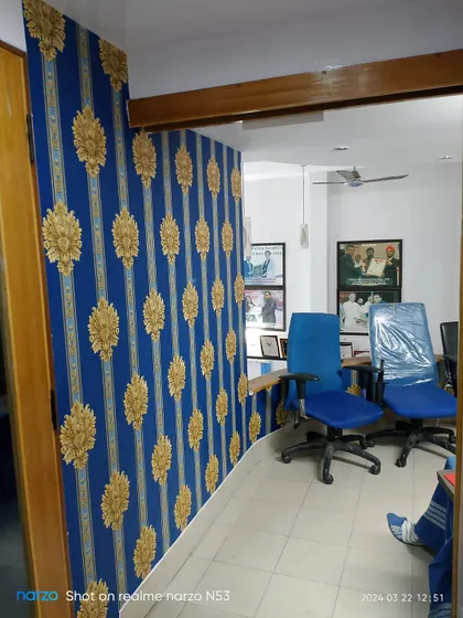 A bold blue and gold damask wallpaper installed in an office corridor.
