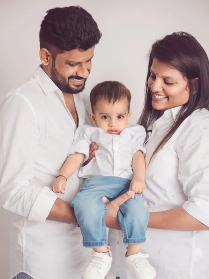 A close-up of this lovely family, capturing the warm smiles and connection between them. The simple white background keeps all the focus on their happiness.