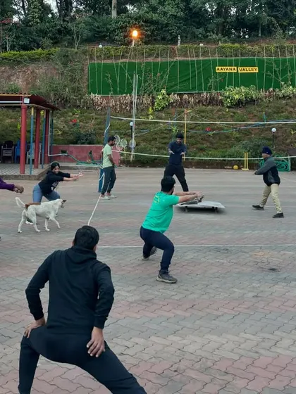 Even the local pets sometimes join in the fun. Here, a team engages in a warm-up activity, getting ready for a day of challenges and friendly competition at a resort.