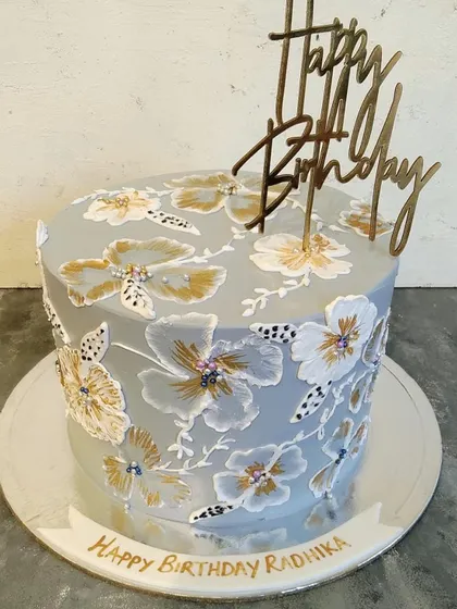 This cake is a canvas. We used buttercream to paint this intricate floral pattern, creating a unique and artistic centerpiece for a special birthday.