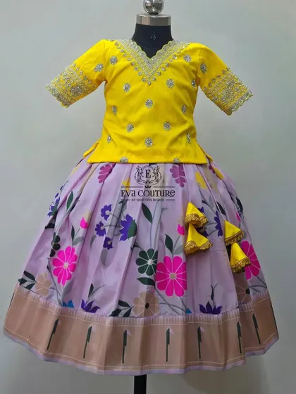 A similar design with a yellow blouse and a floral printed skirt. The V-neck is adorned with silver and grey embroidery.