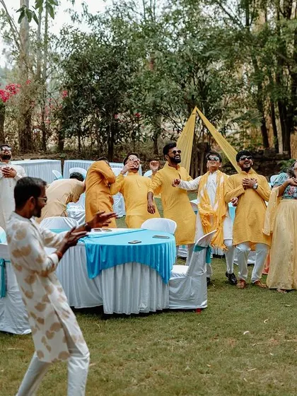 The groom's friends dance and celebrate during the Haldi ceremony, creating a lively and energetic atmosphere.