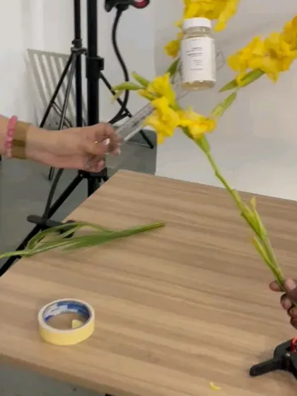 The process of creating the floating flower shot for Atom Health, with hands holding the product and flowers in place.