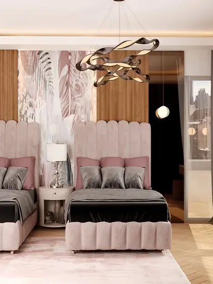 An elegant shared bedroom with two plush pink upholstered beds, a shared nightstand, and sophisticated wall paneling.