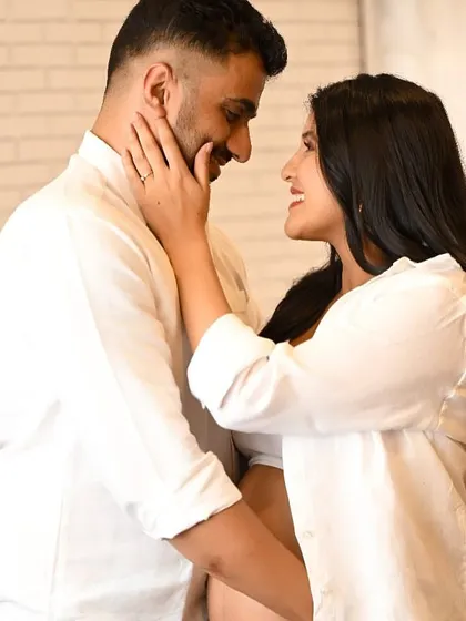 An intimate close-up of an expecting couple, capturing a gentle touch and a loving gaze during their maternity photoshoot.