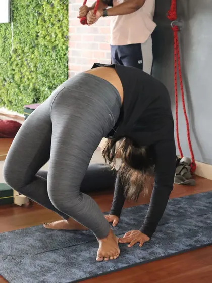 A student practices Urdhva Dhanurasana (Wheel Pose), demonstrating great strength in her arms and legs.