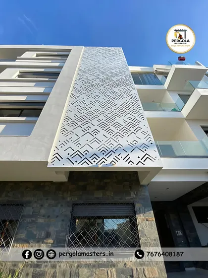 A large-scale architectural facade on a modern apartment building, featuring a custom geometric pattern created with precision laser cutting. This demonstrates our capability to execute complex, large-format metalwork for commercial and multi-unit residential projects.