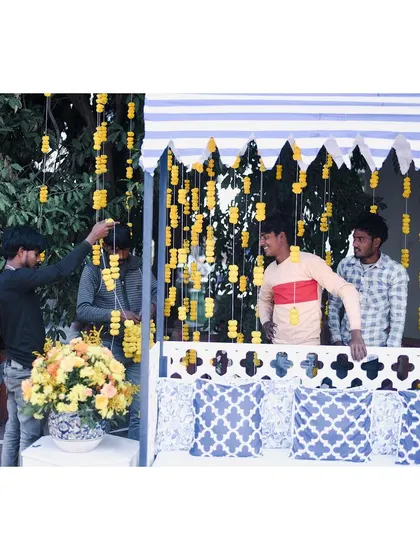 Behind the scenes at the blue and yellow Haldi, with our team setting up the marigold strings. It's the hard work of these artists that brings every vision to life.