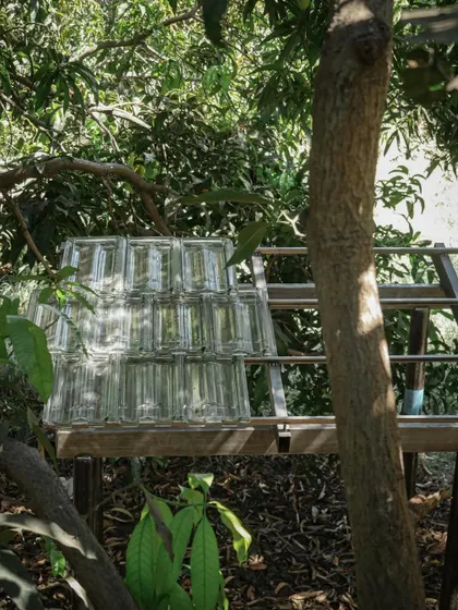 A mock-up of a glass block wall, set up in the shade of a mango tree. This helps us understand the level of transparency and texture the final wall will have.