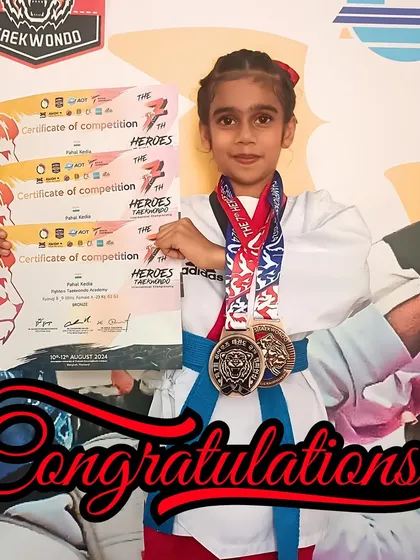 The rewards of dedication. Pahal holds her certificates of competition and bronze medals, representing her outstanding performance against international competitors.