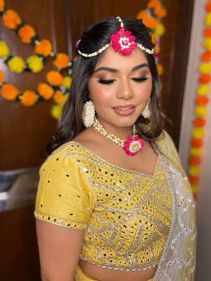 A close-up of Simran's mehendi makeup. The soft gold eyeshadow and winged liner make her eyes shine, perfectly complementing her yellow outfit.