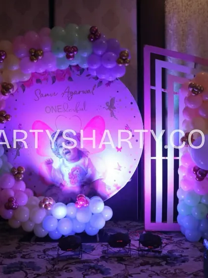 A custom circular backdrop with a photo of the birthday girl, surrounded by a pastel balloon garland, perfect for cake cutting ceremonies.