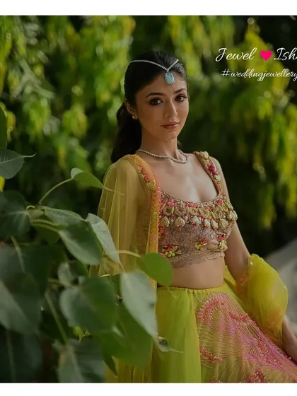 A vibrant and modern Mehendi look. This bride pairs a neon green and pink lehenga with our minimal diamond necklace and a statement turquoise sheeshpatti for a look that is fun, fresh, and totally unique.