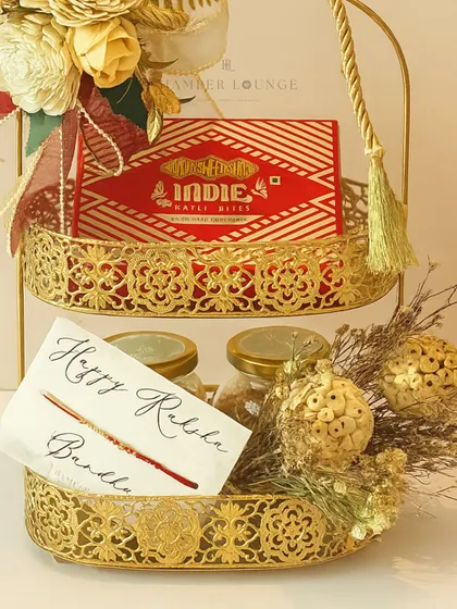 A closer look at the luxe gold caddy for Rakhi, highlighting the Indie Myle Bites from Bombay Sweet Shop and the jars of gourmet dry fruits.