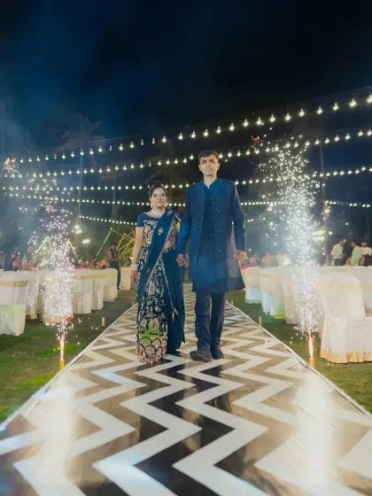 The full view of the couple's Sangeet entrance, showing the stylish patterned walkway and the dramatic effect of the cold pyro sparklers.