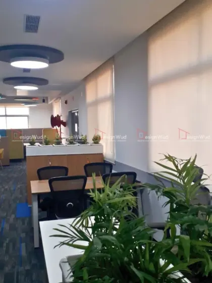 We incorporate biophilic design elements like indoor plants to improve air quality and create a more pleasant work environment. This image shows planters placed strategically between workstation clusters, breaking the monotony and adding a natural touch.