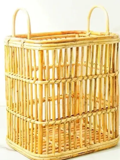 This sturdy and spacious rectangular laundry or storage basket is crafted from natural cane. Its simple, open design and integrated handles make it a versatile piece for organizing any corner of your living space.