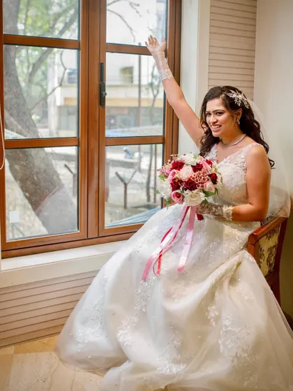 A joyful, candid moment by the window. Her happiness is palpable, and her makeup is fresh and glowing.