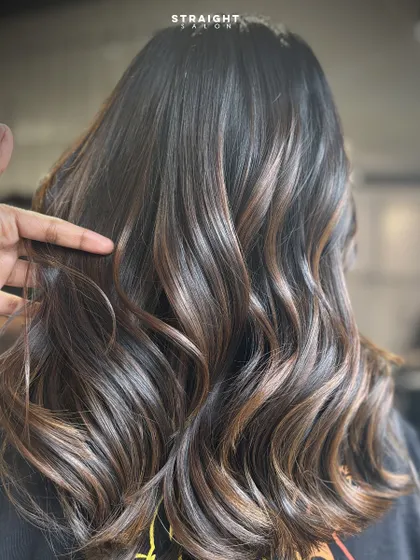 When the shine hits just right. This is a perfect example of a glossy brunette balayage, styled into sleek, defined waves.