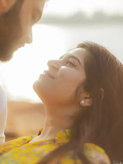A backlit close-up capturing the loving gaze between the couple, with the sun creating a beautiful, soft halo effect.