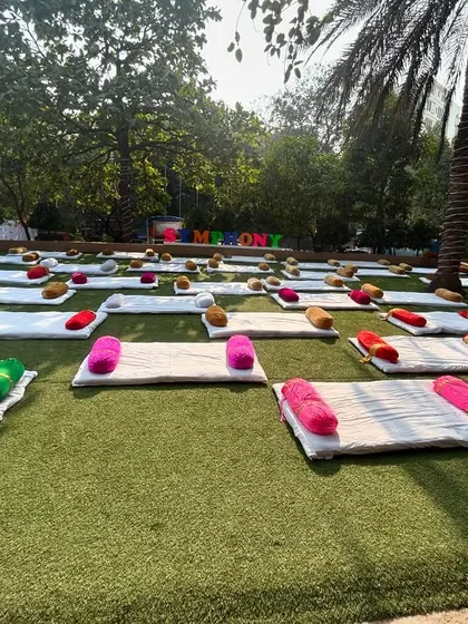 An outdoor setup for a carnival event in Juhu. We arranged comfortable floor seating with mattresses and colorful cushions on the lawn for a relaxed, festive atmosphere.