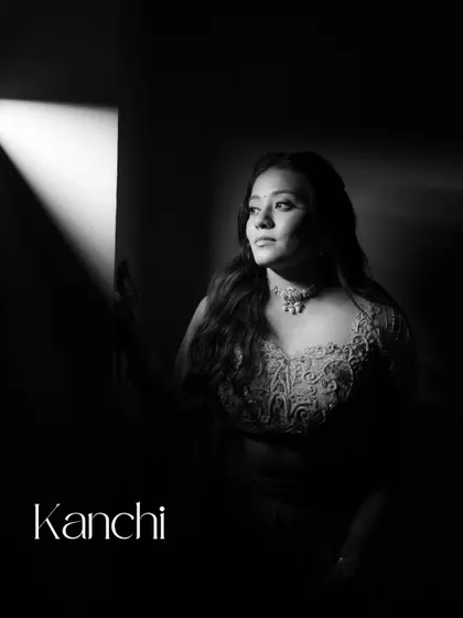 A dramatic black and white portrait of the bride-to-be, Kanchi. The play of light and shadow creates a powerful and artistic image, highlighting her contemplative beauty.
