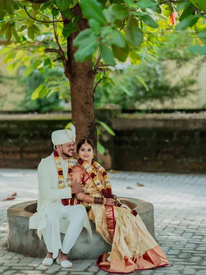 A peaceful portrait of the newlyweds sitting under a tree, a quiet moment of togetherness after their wedding ceremony.