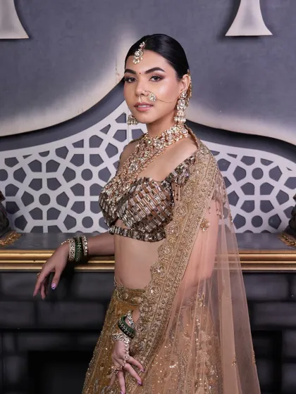 This full view shows how a polished low bun provides a sophisticated foundation for a heavy dupatta and elaborate bridal jewelry, ensuring a regal and put-together look.